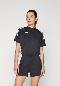 Juodas sportinis rinkinys su trumpomis rankovėmis ir šortais, su baltais akcentais ir Adidas logotipu. Pagamintas iš lengvos medžiagos, užtikrinančios komfortą.