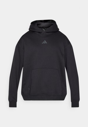Musta huppari, valmistettu pehmeästä kankaasta, jossa on kengurutasku, resorit hihansuuissa ja pieni harmaa Adidas-logo rinnassa.