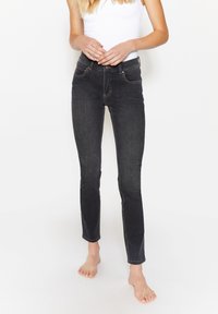 Jeans skinny neri a vita alta in denim; presentano tasche frontali, cuciture in contrasto e un design aderente.