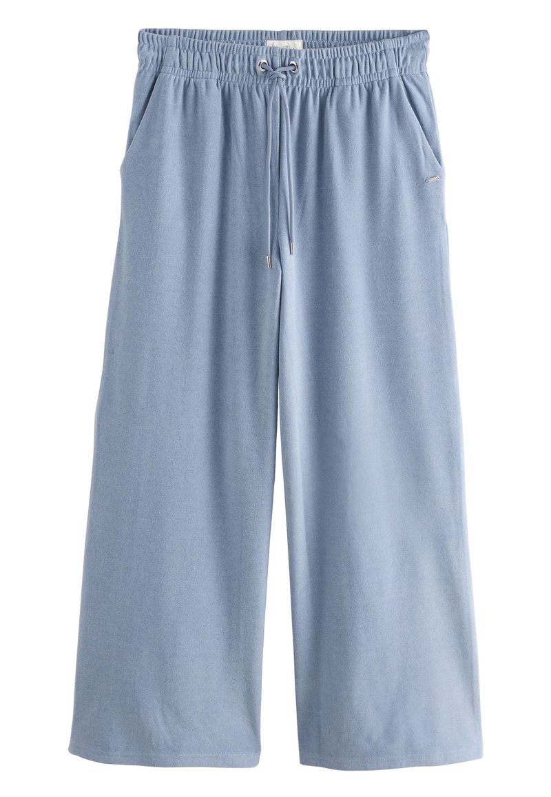Pantalon large bleu clair en tissu doux. Dispose d'une ceinture élastique avec un cordon de serrage, deux poches latérales et une texture lisse.