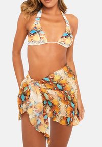 Triangelbikini i texturerad tyg med ett ormskinnsmönster i orange, gult och turkost, kompletterad med en matchande wrapkjol.