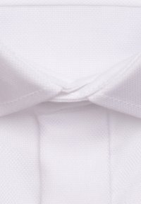 Col de chemise blanche avec une texture lisse et un design pointu, avec des coutures visibles et un pli classique.