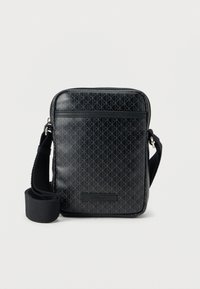 Μαύρη τσάντα χιαστί από υλικό συνθετικής υφής, με διακριτικό γεωμετρικό μοτίβο, ρυθμιζόμενο λουράκι και κλείσιμο με φερμουάρ στην κορυφή.
