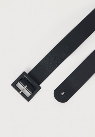 Μαύρη δερμάτινη ζώνη με τετράγωνη μεταλλική αγκράφα και διακοσμητική ασημένια μέλισσα στην άκρη. Λείο υφή και μινιμαλιστικός σχεδιασμός.