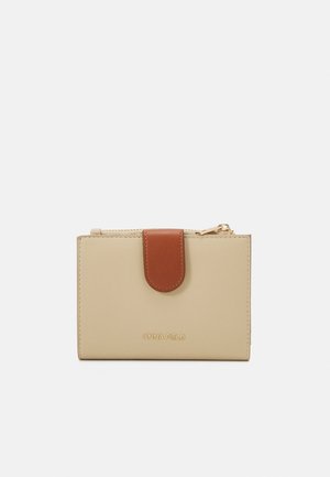 Beige Kunstleder-Geldbörse mit einer braunen magnetischen Klappe und goldenen Reißverschluss, mit geprägtem Branding. Kompaktes, rechteckiges Design.