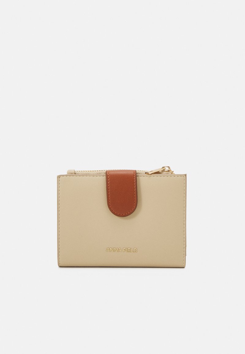 Portafoglio in finta pelle beige con patta magnetica marrone e zip dorata, con branding in rilievo. Design compatto e rettangolare.
