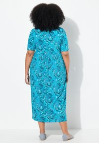Maxi sukienka w jasnym turkusowym kolorze z kwiatowymi i paisleyowymi wzorami. Krótkie rękawy, dopasowany talia i lejąca spódnica o miękkiej teksturze materiału.