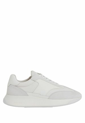 Hvid lavtop sneakers med ruskind og læder paneler, snørelukning foran og tyk gummisål, vist fra siden på en hvid baggrund.