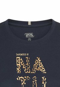 Mørkeblå T-shirt med rund hals, prydet med et leopardmønster i guld og teksten "EMPOWERED BY" ovenover. Mærket label synlig indeni.