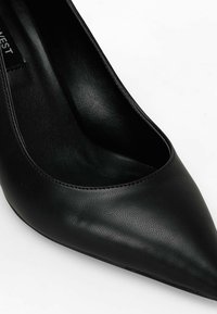 Black leather high-heeled shoe with a pointed toe and a smooth texture, featuring a low-cut vamp for a sleek silhouette.