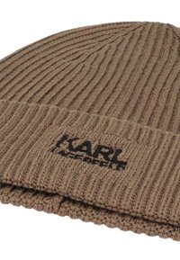 Bruine gebreide beanie met ribbelstructuur, voorzien van een omgeslagen rand en een zwart logo geborduurd aan de voorkant. Zacht, wolachtig materiaal.