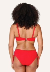 Červený bikinový set s textúrovanou látkou, nastaviteľnými popruhmi a zapínaním na chrbte, s viazanými stranami na spodnom diele.