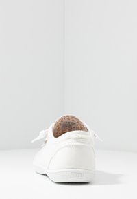 White canvas sneaker with a textured finish, featuring a round toe, lace-up design, and a patterned interior lining. "BOBS" logo on heel.