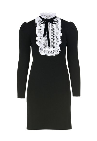 Schwarzes Langarmkleid aus strukturiertem Stoff, mit einem weißen Spitzenkragen und einer Schleifendetail. Figurbetonte Silhouette mit geschoppten Schultern.