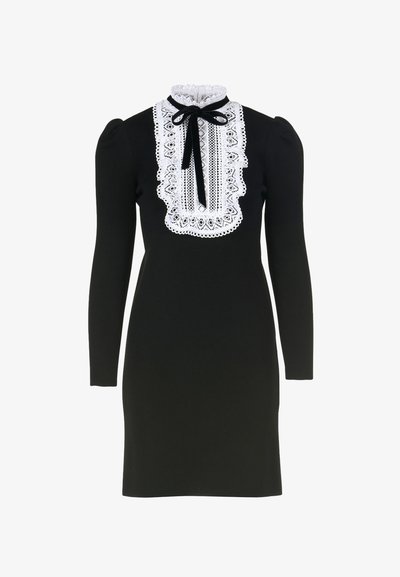 Juoda ilgomis rankovėmis suknele, pagaminta iš tekstūruoto audinio, su balta nėriniuota apykakle ir kaspino detale. Prigludusi siluetas su pūstomis pečių dalimis.