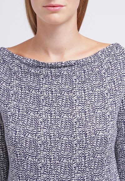 Blouse à motifs bleu marine et gris clair avec un décolleté bateau, fabriquée dans un tissu doux et texturé, à coupe décontractée, manches courtes et détails minimalistes.