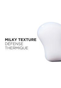 Produkt med melkeaktig tekstur og myk, avrundet form. Inneholder teksten: "MILKY TEXTURE DÉFENSE THERMIQUE" i fet svart skrift på hvit bakgrunn.
