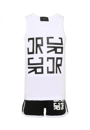 Biały top bez rękawów z abstrakcyjnymi czarnymi blokowymi literami oraz czarne szorty z białą lamówką i pasującymi czarnymi literami blokowymi.