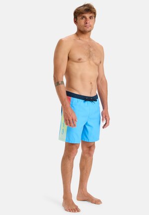 Shorts de bain bleus avec un cordon noir et des accents latéraux en vert clair et rose. Fabriqués en matériau léger et à séchage rapide.