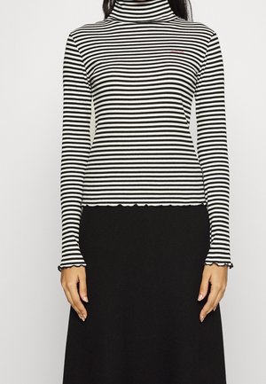 Pull en laine à col roulé à manches longues rayé noir et blanc avec un ourlet et des poignets à festons, en tissu texturé, comportant un petit logo brodé.