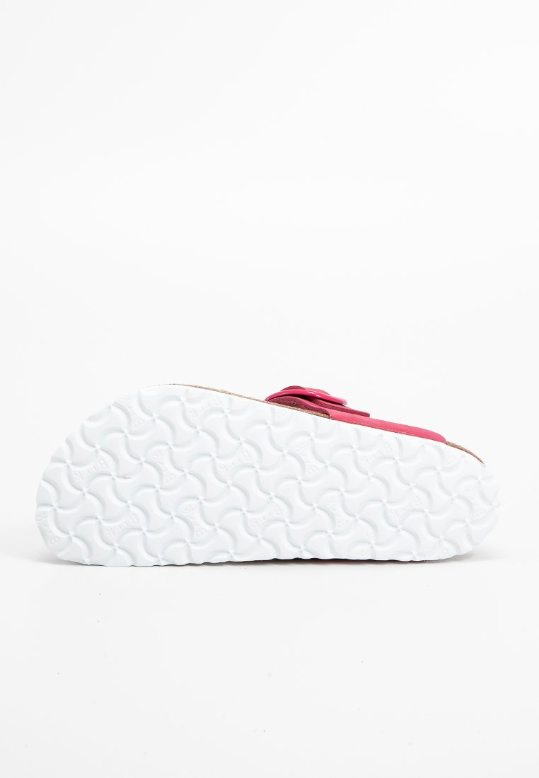 Schuhe mit einem leuchtend pinken Obermaterial und einer weißen Gummisohle, die ein wellenförmiges Muster für besseren Halt bietet und für Komfort und Freizeitgestaltung konzipiert ist.