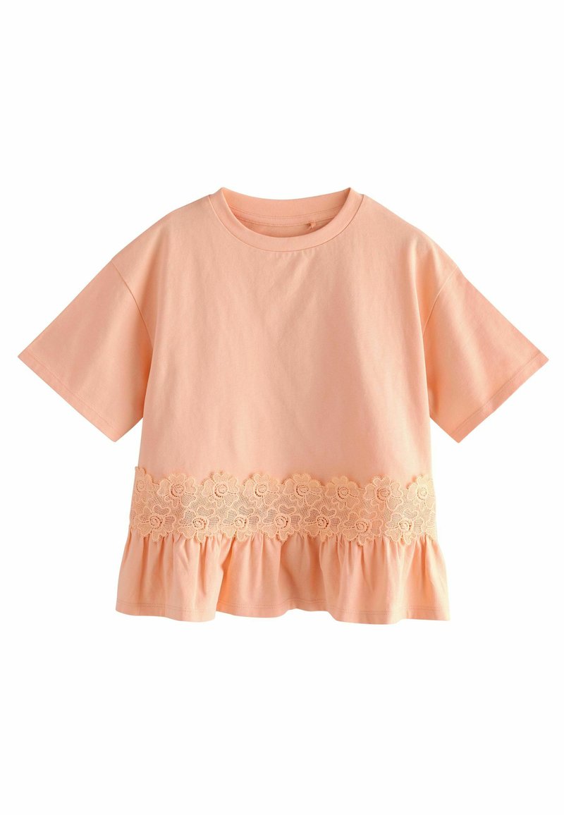 Pfirsichfarbene Baumwoll-T-Shirt mit runder Ausschnitt, kurzen Ärmeln und einem gerafften Saum. Verfügt über einen Spitzenblumenbesatz in der Taille.
