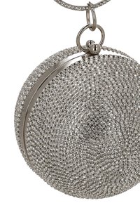 Bolso de mano redondo plateado con una superficie texturizada cubierta de pequeños brillantes de strass. Presenta un cierre de aro metálico y un acento metálico liso.