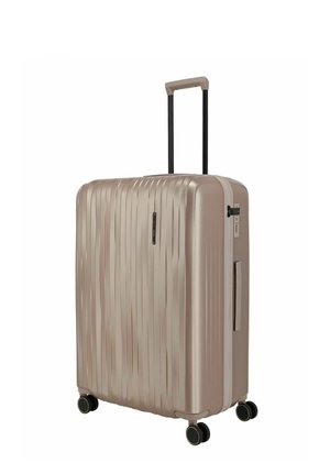 Valise rigide beige avec des rainures verticales, quatre roues pivotantes, poignée télescopique, poignée latérale et serrure à combinaison intégrée.