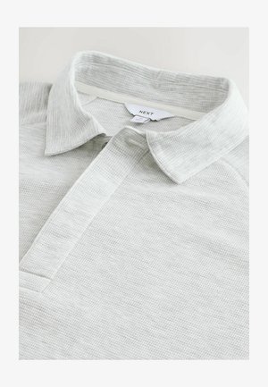 Helehall polo särk, mis on valmistatud tekstureeritud kangast, nööpidega krae ja lühikeste varrukatega, lihtsa disainiga ning peente õmblusdetailidega.