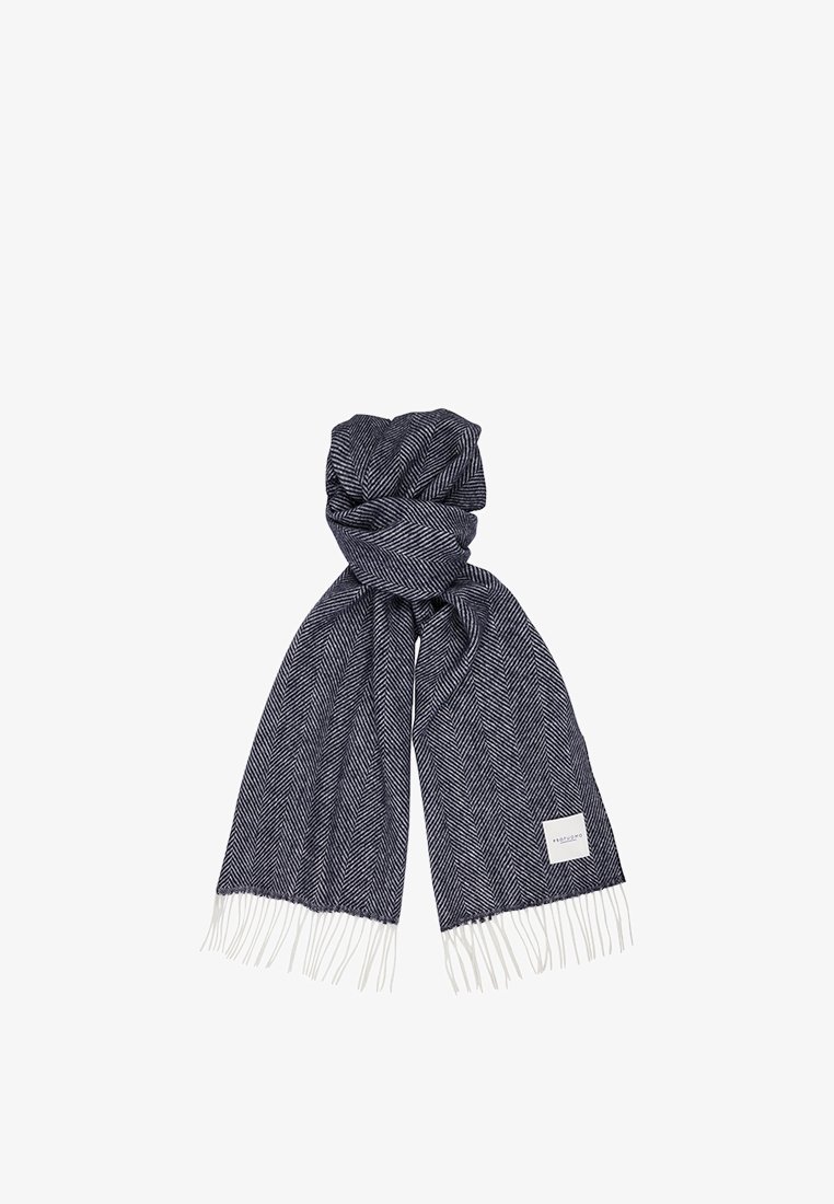 Écharpe à motif chevron en marine foncé et blanc. Présente des bords à franges et une petite étiquette blanche. Fabriquée en tissu doux et texturé.
