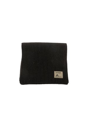 Berretto in maglia nera con costine verticali. Presenta un'etichetta rettangolare beige con del testo. Texture morbida e design pieghevole.
