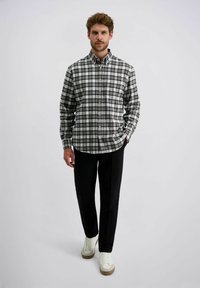 Gestreepte knopshirt in grijs en wit, van katoen, met een ontspannen pasvorm, gecombineerd met zwarte broek en lichte sneakers, met een gebogen zoom.