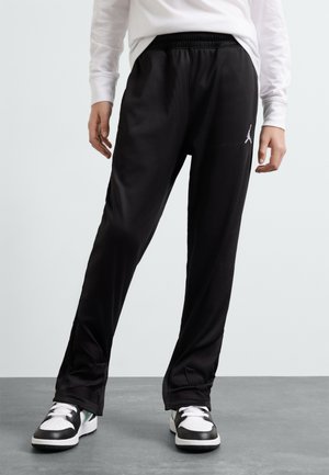 Schwarze Sporthose aus glattem Material, mit elastischem Bund, seitlichen Taschen und einem dezenten weißen Jordan-Logo auf dem linken Oberschenkel.