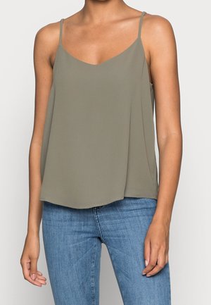 Haut sans manches vert olive avec un col en V et des bretelles fines ; tissu léger, design fluide et ourlet arrondi ; porté avec un jean bleu.