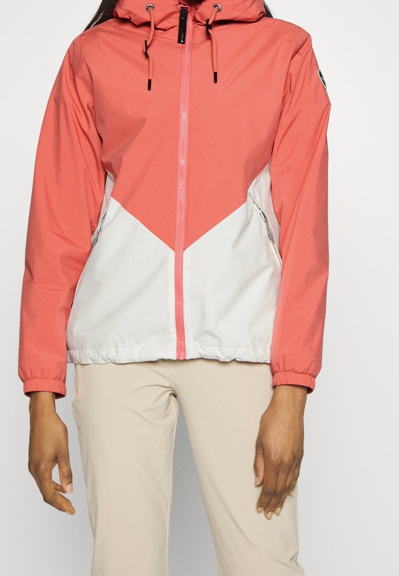 Chaqueta cortavientos en coral y blanco, con diseño en cheurón, capucha ajustable con cordones y bolsillos laterales con cremallera.