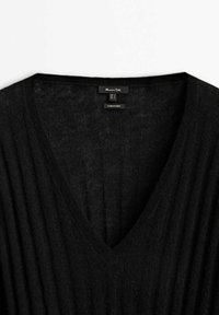 Pull noir en maille côtelée avec col en V et étiquette "Massimo Dutti" visible à l'intérieur du col.