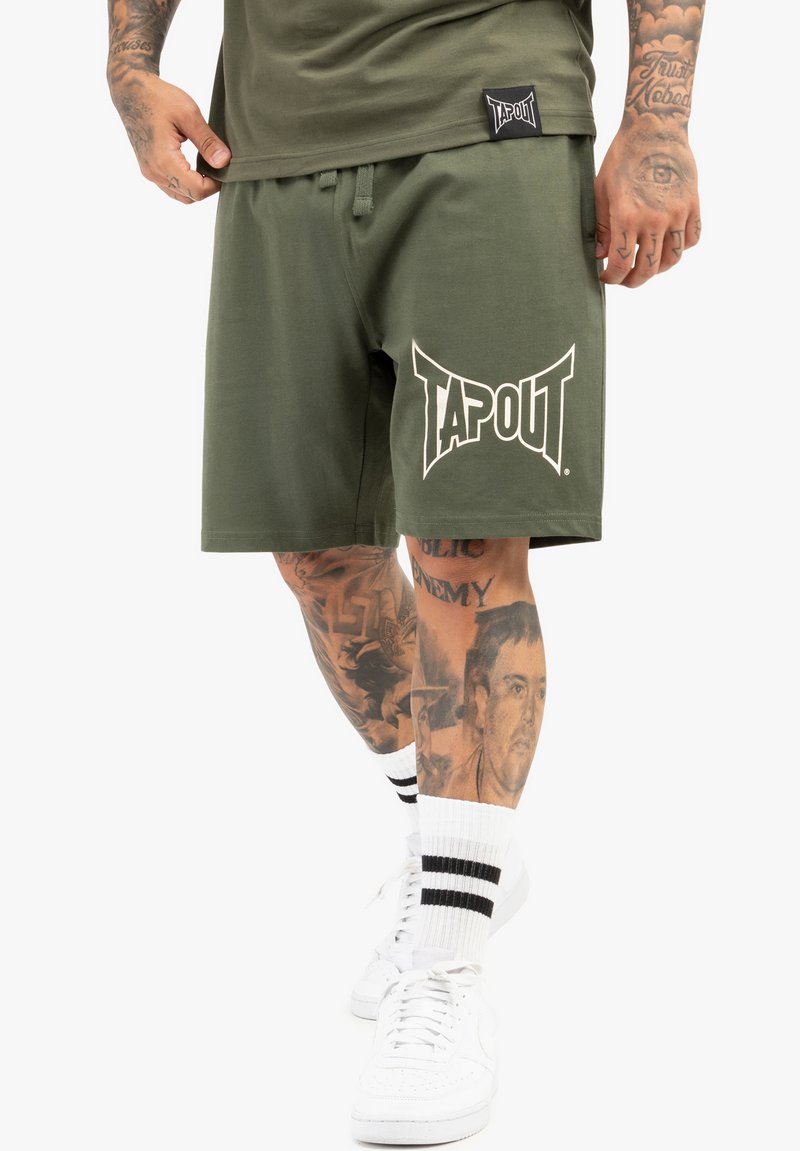 Olivengrønne shorts lavet af bomuld, med et fremtrædende hvidt "TAPOUT"-logo på venstre ben, samt elastisk talje og snor.