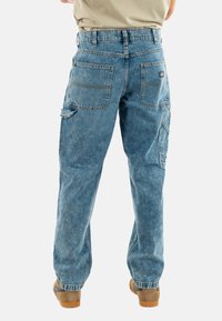 Lichtblauwe denim broek met een relaxte pasvorm, met meerdere zakken, zichtbare stiksels en een tailleband met riemlussen.