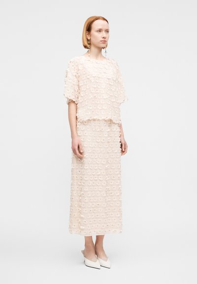 Ροζ ανοιχτό ροζ δύο τεμαχίων φόρεμα, με υφή κομμένου λουλουδιού ύφασμα, κοντά μανίκια και φούστα μεσαίου μήκους. Κομψή εφαρμοστή σιλουέτα.