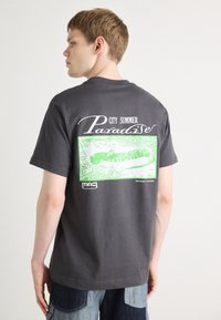 Šedé bavlněné tričko s velkým zeleným grafickým designem a nápisem "CITY SUMMER Paradise" na zadní straně, krátké rukávy, volný střih.