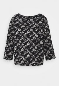 Svart och vitmönstrad överdel med trekvartslånga ärmar, rundhals och lös passform. Tillverkad av mjukt tyg med en slät textur.