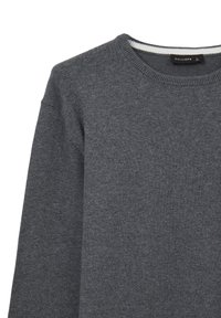 Dunkelgrauer, langärmliger Strickpullover mit geripptem Rundhalsausschnitt und kleinem Markenlabel im Kragen.