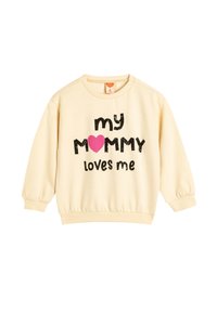 Lichtcrème sweatshirt met lange, opbollende mouwen. Bevat zwarte, vetgedrukte tekst die zegt "mijn MAMMA houdt van mij" met een roze hartaccent.