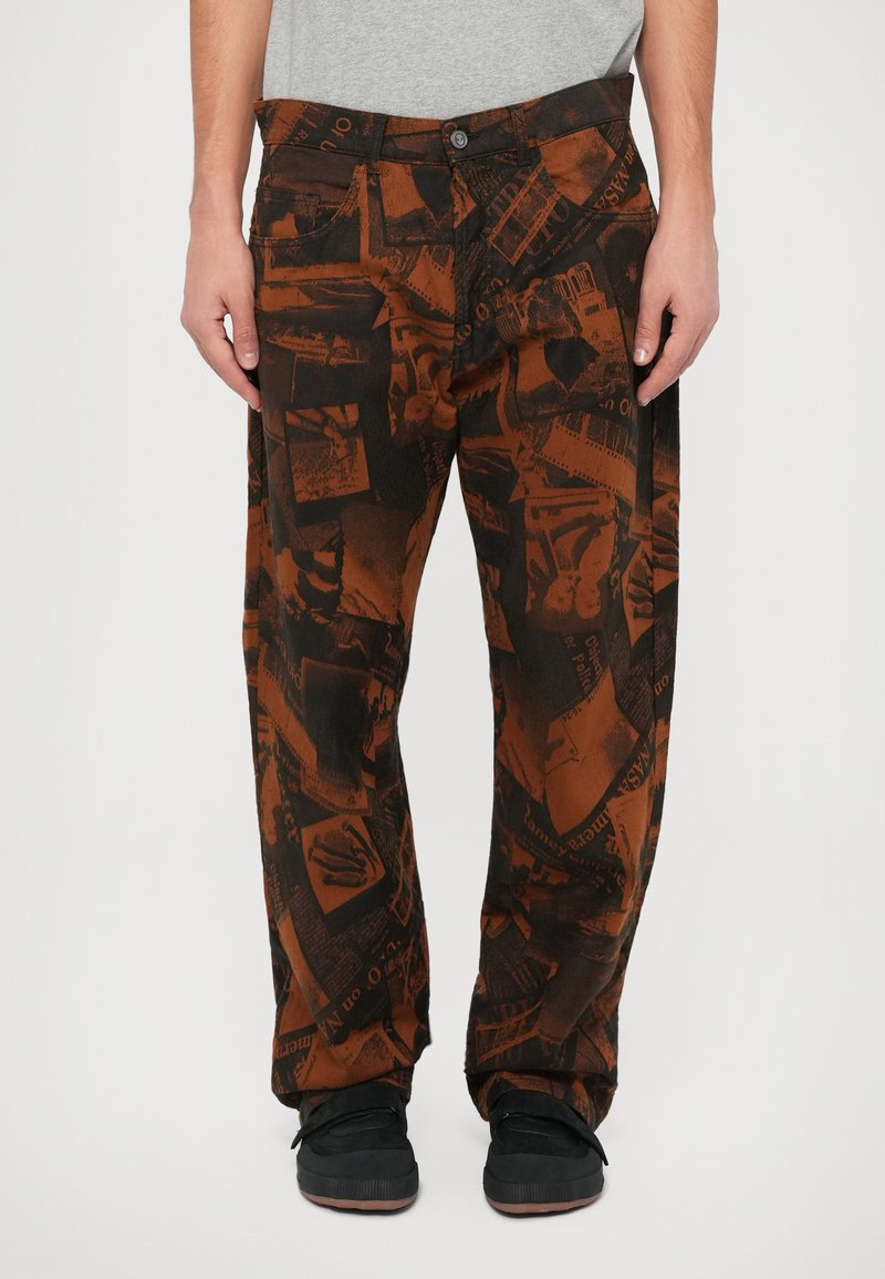 Braune Hose mit einem Muster aus verschiedenen gedruckten Grafiken, aus einem weichen Stoff, mit einer lockeren Passform und zwei Fronttaschen.