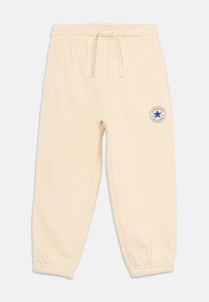 Beežid fliisist dressipüksid elastse vöökoha ja mansettidega, paelaga ning väike Converse All Star logo vasakul reiel.