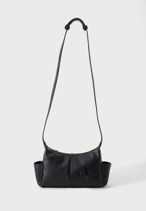Sort læder crossbody-taske med lang justerbar rem, sidelommer, lynlåslukning og præget Calvin Klein-logo på forsiden.