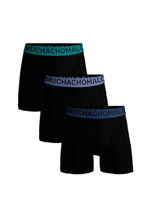 Tri páry čiernych boxeriek s kontrastnými elastickými pásmi; dve majú tyrkysovú farbu a jedna svetlomodrú s textom "MUCHACHOMALO".