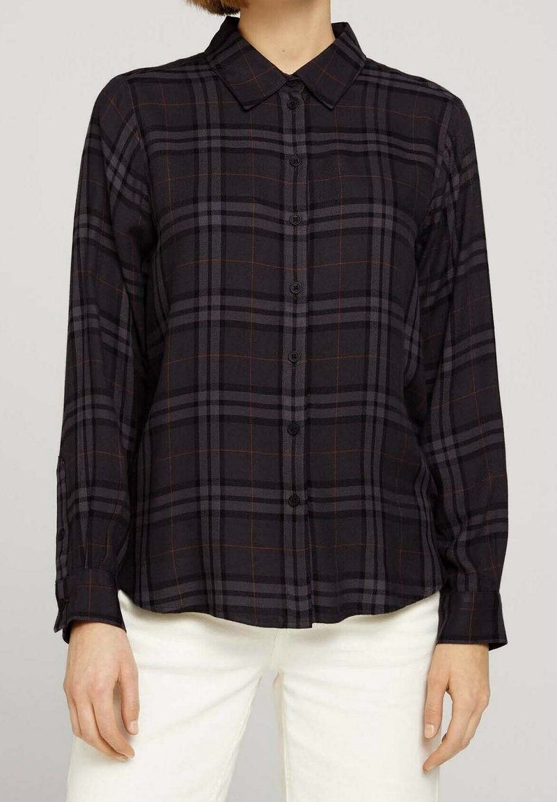 Svart och grå rutig skjorta med nedknäppt krage, långa ärmar och avslappnad passform. Har orangea accentlinjer och knappstängning.