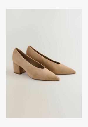 Beige suède pumps met blokhak, een spitse neus en een gladde textuur. Kenmerkt zich door een minimalistisch ontwerp en een stevige, iets vierkante hak.
