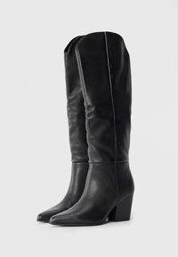 Bottes noires en cuir montantes jusqu'au genou avec un bout pointu, un tige ajustée et un talon bloc ; texture lisse avec des détails de couture subtils.
